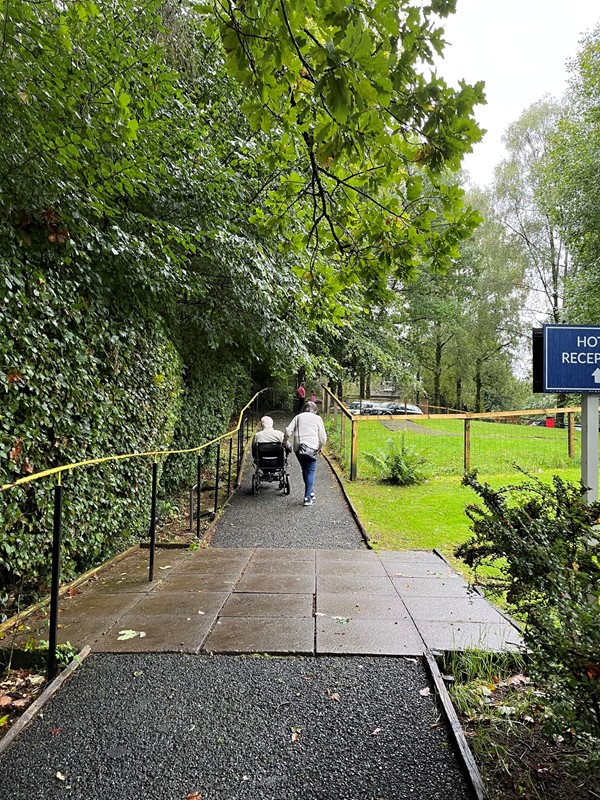 Heading for reception from rear accommodation.  Look at the angle on those hand rails…. My power chair was in danger of tipping backwards and I found tree roots across the path disconcerting.