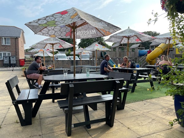 Image of a people sitting at tables and umbrellas