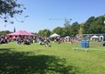 Photo of people sitting in front of the main stage on  the grass.