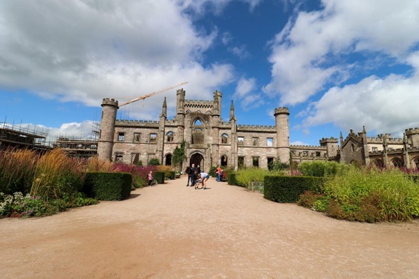 Castle with gardens in front and a sandy but hard path which is really wide.