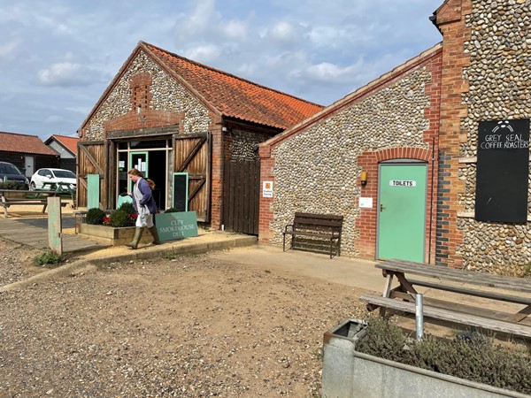 Toilet entrance with disabled parking space and cafe next door,