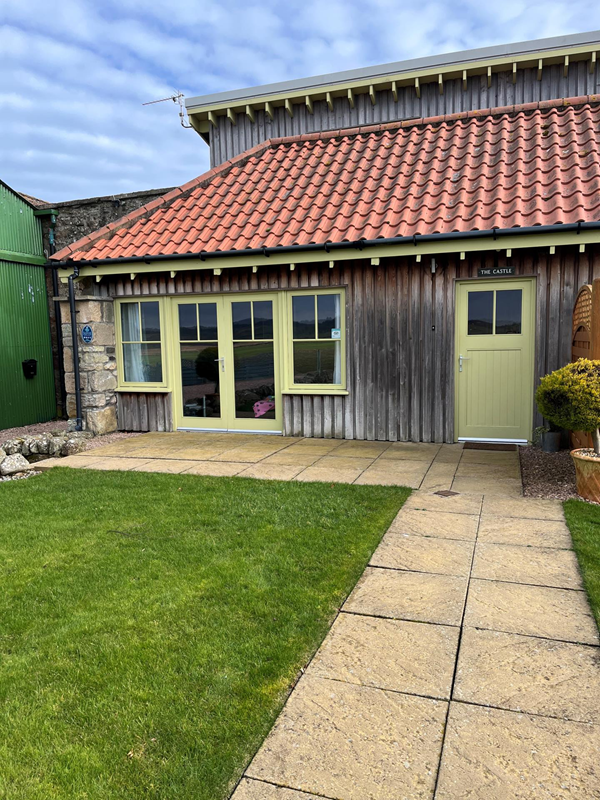 Exterior of The Castle Coach House. Smooth paths and patio areas, and level entrances.