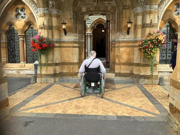 Image of a wheelchair user heading towards a door