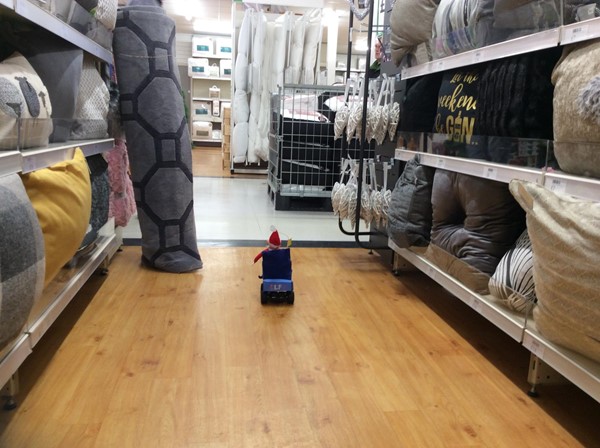 Carpet rolled up and leaning at the edge of an aisle.