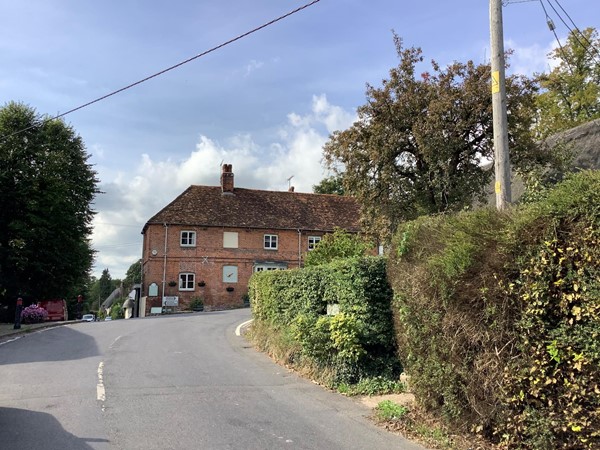 Road leading to a red brick house