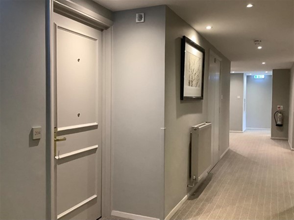 Image of a hallway with a door and a radiator