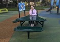 Image of reviewer sitting at wheelchair accessible picnic table.