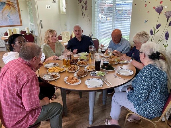 Image of a group of people sitting around a table eating food