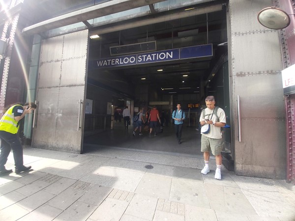 Image of a group of people walking in front of a railway station