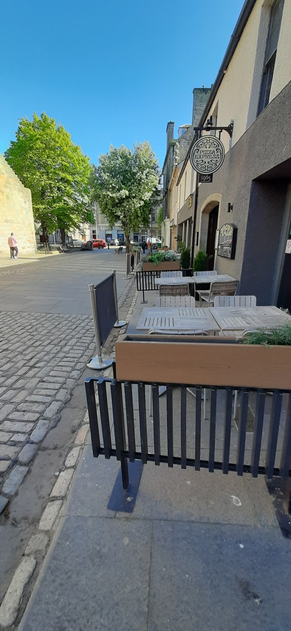 Image of a pavement. with tables and chairs