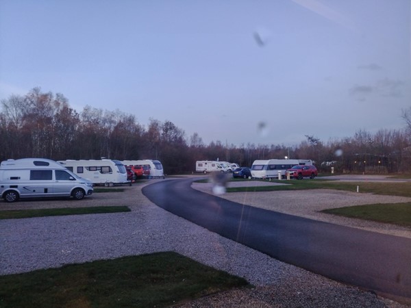 View out of motorhome window, complete with rain, showing tarmacked road and nice tidy pitches.