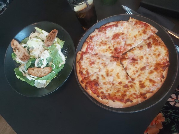 Image of a pizza and salad on a table