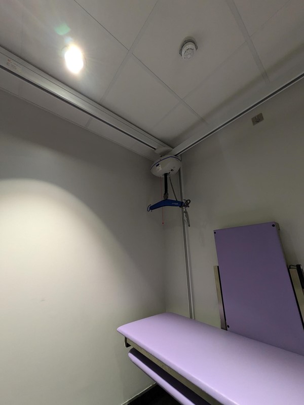 Image of the hoist and purple change bed in the Changing Places Toilet.