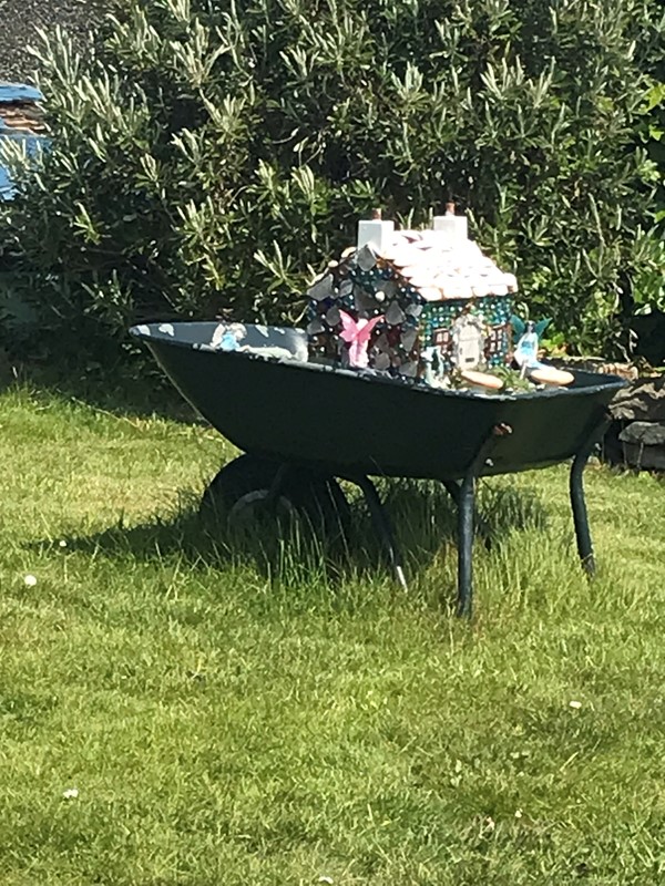 Decorative novelty fairy house in a wheelbarrow