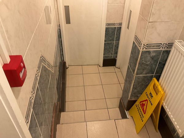 Image of a  yellow sign on a tile floor