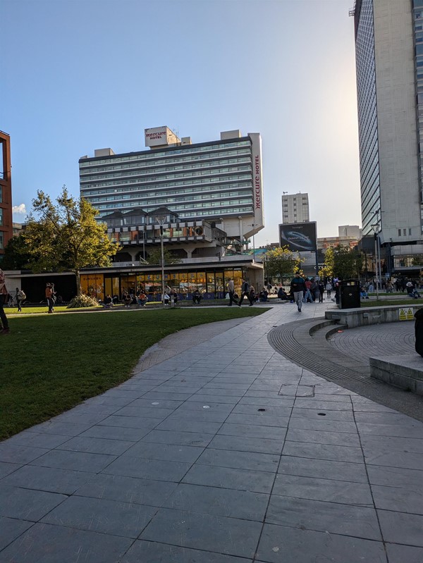 Image of a flat path with a building in the distance and grass on the right