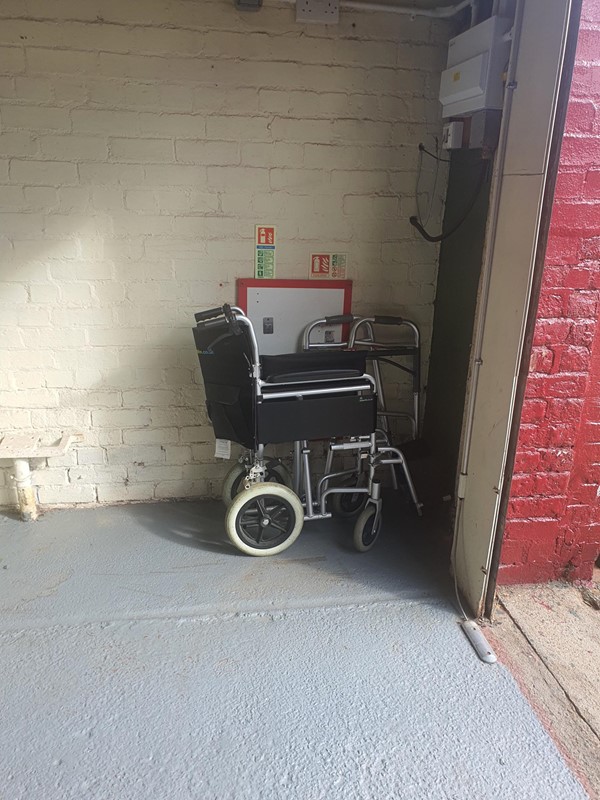 Image of a folded up manual wheelchair near the exit to the museum.