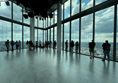 Image of a group of people standing in a room with large windows