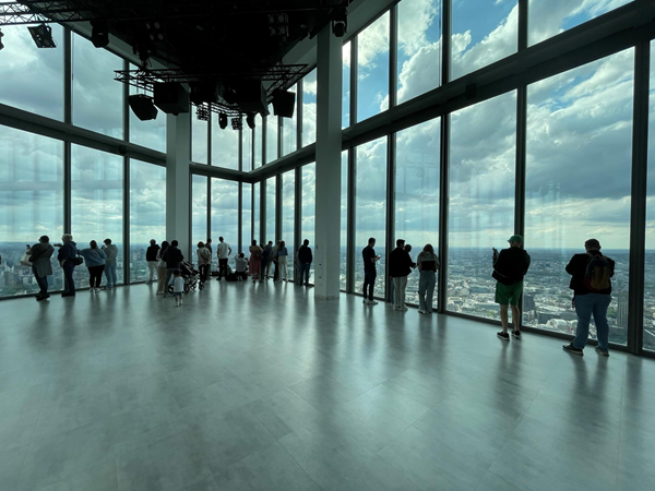 Image of a group of people standing in a room with large windows