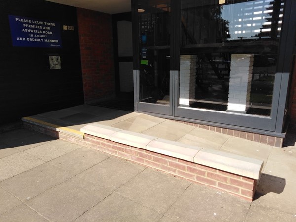 Image of a brick wall in front of a building