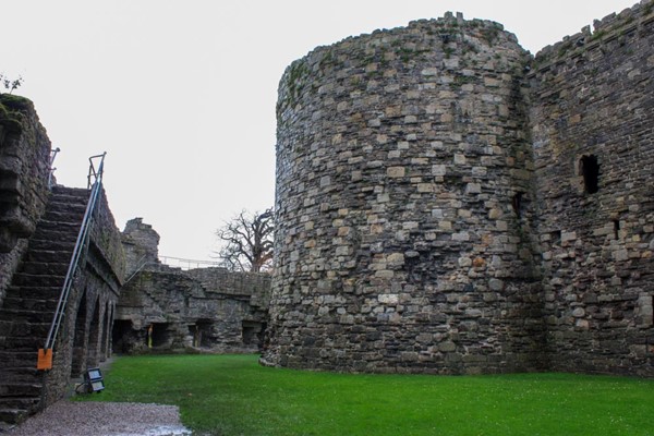 Inside the castle walls, grass surface ahead and a long flight of stone steps up the outer wall on the left.