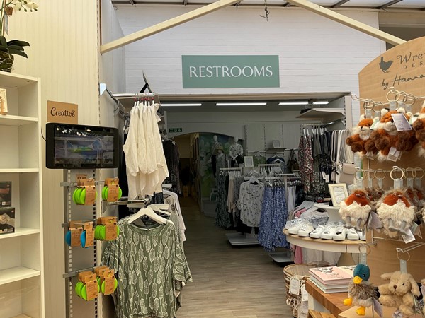 Image of a restroom sign and a shelf with clothes