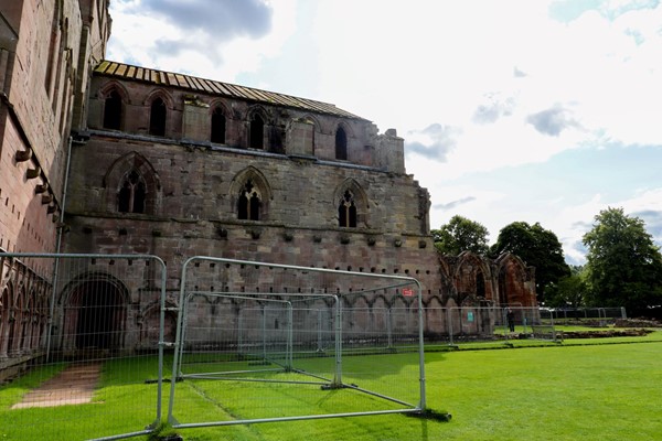 Grassy grounds with the abbey fenced off to visitors.