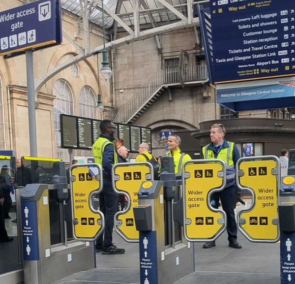 A group of people standing in front of a ticket gate