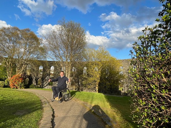 Image of Paul sitting facing the camera on the pathway.