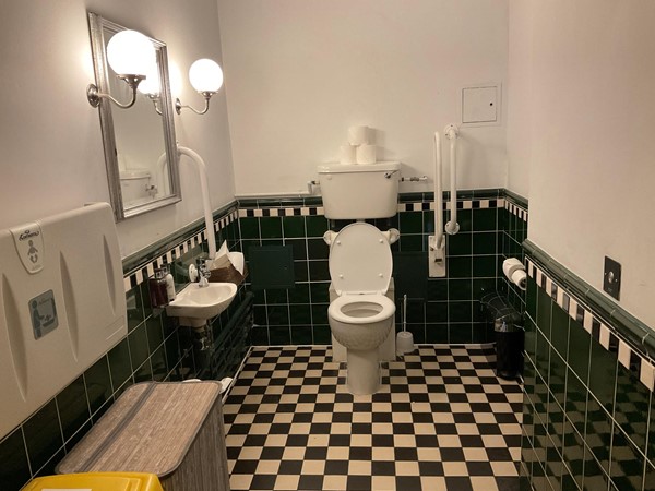 It’s along here you will find the accessible toilet, which was nicely decorated with dark tiles, and plain simple coloured walls, large enough to hold almost all chairs and room to spin around. It had a number of pull grab handles, but no pull cord.