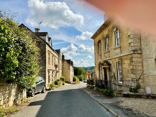 Image of a street with buildings and cars on the side