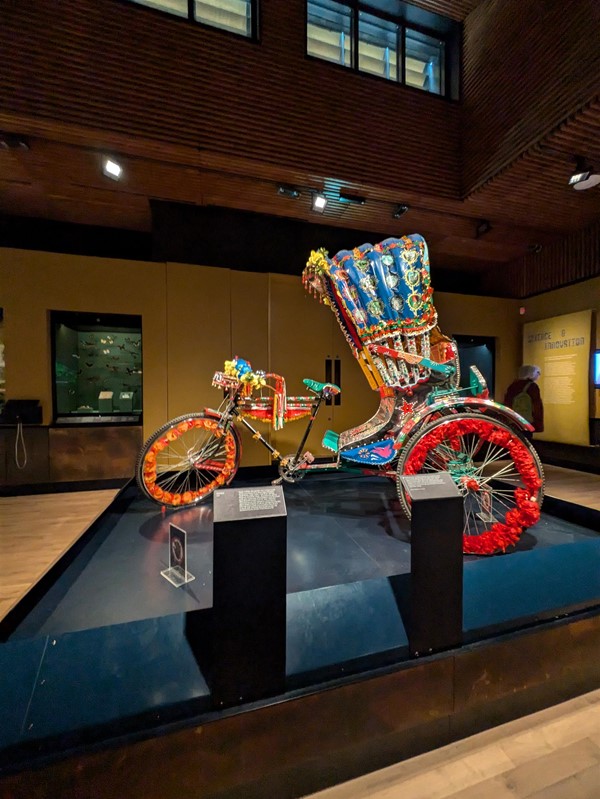 Image of a tricycle with canopy decorated with colourful flowers