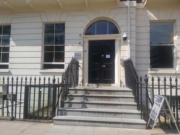 Image of a building with stairs and a black door