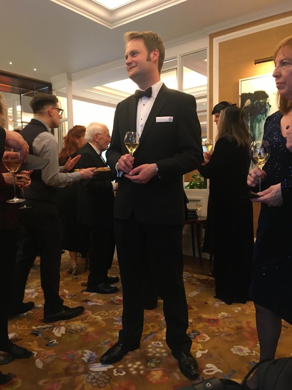 Man in a suit with a glass of wine