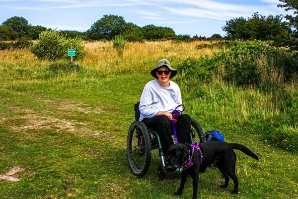 At the far end of the accessible path is a small beach area, though this is still grass. I'm in my mountain trike, holding onto my dog because there was blue-green algae in the dam, so not possible to let her paddle.