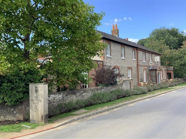 Image of a street with a brick building and a tree