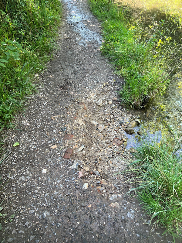 Pothole on the river side, nettles on the other.