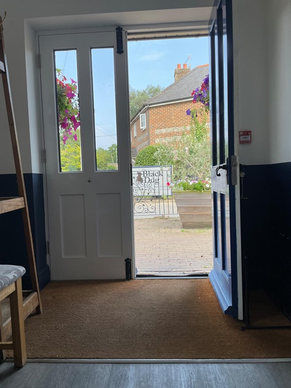 Image of a door with glass panels and a chair in front of a building