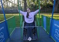 Image of reviewer on wheelchair accessible swing.