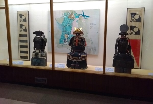 Suits of armour and war flags on display.