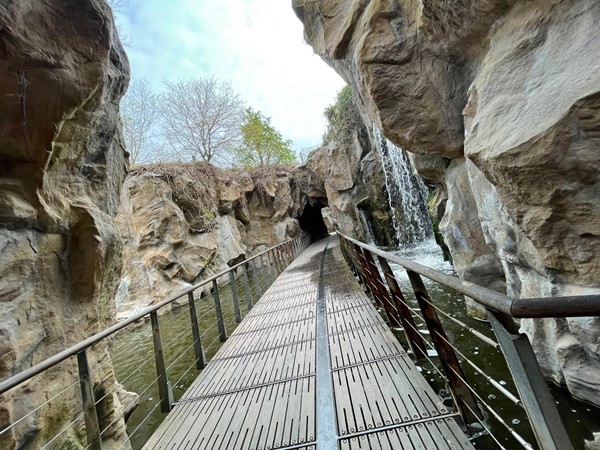 The suspended walkway through the rock gorge with its cascading waterfalls