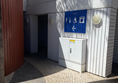 image of outside of toilet facilities with large blue sign on a white building