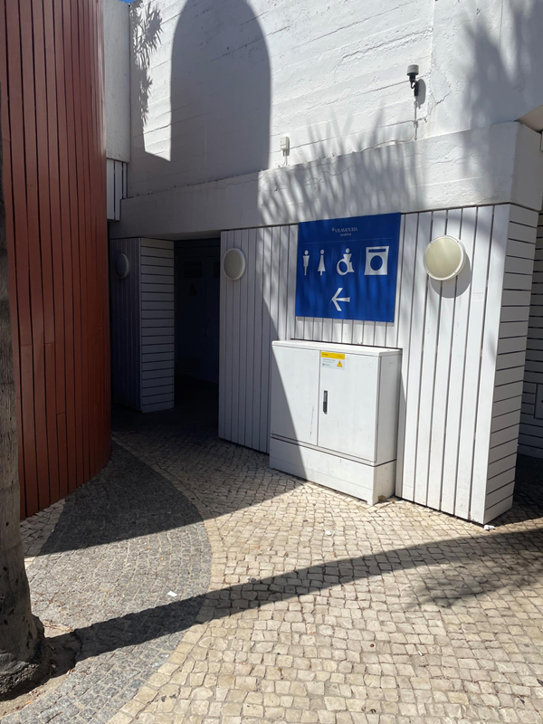 image of outside of toilet facilities with large blue sign on a white building