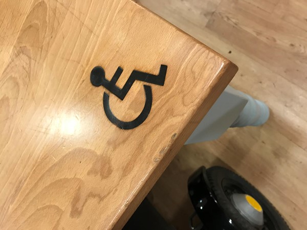 Photo shows a picture of the wheelchair sign that is found on the higher tables.