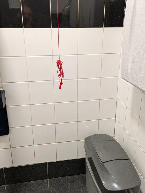 Image of red emergency cord, its tied up and the plastic bangles are broken