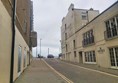 Image of a  street with buildings and cars on it