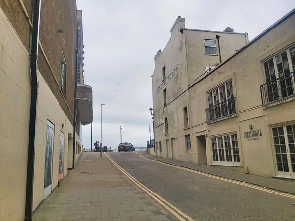 Image of a  street with buildings and cars on it