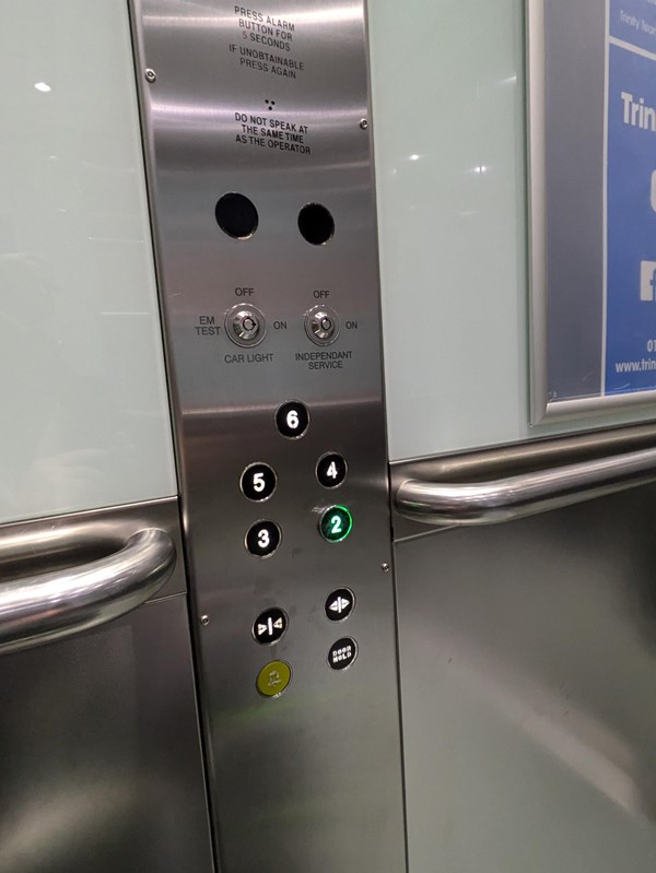 image of the lift buttons, they do not have Braille markings