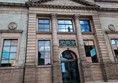 Exterior image of Aberdeen Art Gallery. an old sandstone with large windows and gold lettering that reads ART GALLERY above the door.