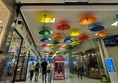 Image of the inside of the centre, tiled black and white floors, with colorful umbrellas on the white roof